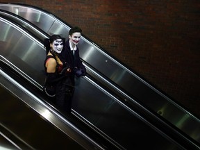 A couple dressed for Halloween ride the escalator into a subway station in Somerville, Massachusetts October 31, 2013.  REUTERS/Brian Snyder