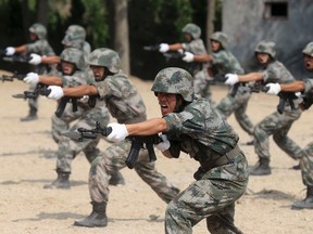 Members of People's Liberation Army (PLA) coastal defence force shout as they practise during a drill to mark the upcoming 87th Army Day at a military base in Qingdao, Shandong province July 29, 2014. (REUTERS/Stringer)