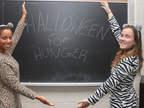 Instead of trick or treating for candy, Celitha Gencarelli, left, and Maria Stakheiko seen here on the morning of Friday October 31, 2014, the two Grade 9 students collect non-perishable food items on Halloween as part of their Halloween for Hunger campaign for the Partners in Mission Food Bank. The two students at Bayridge Secondary school, have dressed up like a cheetah and zebra for the past three years while collecting more than a few hundred donations of food.  Julia McKay/Kingston Whig-Standard/QMI Agency