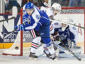 Sudbury Wolves Jeff Corbett (5) and Niagara IceDogs Kyle Langdon (25) eye the loose puck in OHL action Saturday night at the Meridian Centre in St. Catharines, Ont. on Saturday November 1, 2014.  Bob Tymczyszyn/St. Catharines Standard/QMI Agency