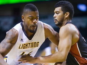 London?s Marvin Phillips drives in on Kevin Loiselle of the Windsor Express during the Lightning?s 99-97 victory in their NBL opener at Budweiser Gardens on Saturday night. (MIKE HENSEN, The London Free Press)