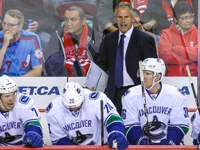 New Vancouver Canucks head coach Willie Desjardins behind the bench against the Flames in Calgary. USA Today photo