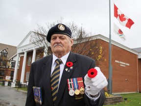 Ron Chafe holds a poppy pin outside the Royal Canadian Legion branch 62 in Sarnia Saturday, moments after raising the Lest We Forget flag to mark the beginning of Remembrance Days. A number of events honouring and remembering Canadian military personnel are planned for the 10-day period leading up to Nov 11. TYLER KULA/ THE OBSERVER/ QMI AGENCY