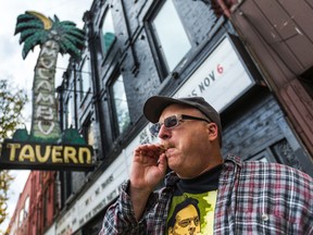 Howard Dover, organizer of the 25th annual medical marijuana comedy show ExtravaGANJA, wearing a Marc Emery t-shirt, sparks up in front the El Mocambo club in Toronto on Wednesday, October 29, 2014. (Ernest Doroszuk/Toronto Sun)
