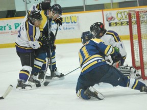 Laurentian Voyageurs' Brandon Francisco, from his knees, tries to shovel in a loose puck in front of the Laurier Gold Hawks' net during OUA men's hockey action at Gerry McCrory Couuntryside Sports Complex. The Voyageurs won 7-6.