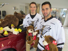 Daniel Nikandrov, left, and Patrick White, with the Sarnia Sting, help kick off the 17th annual Teddy Bear Toss Monday in the showroom at event sponsor, Lambton Ford. Organizers are hoping spectators at the Dec. 7 Sting home game arrive with 3,000 or more stuffed animals to donate by tossing them over the glass to the ice after the home team scores its first goal of the game. The stuff animals go the Salvation Army and other charities (PAUL MORDEN, The Observer)