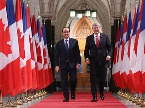 French President Francois Hollande (L) and Canada's Prime Minister Stephen Harper walk down the Hall of Honour in the Parliament Buildings in Ottawa November 3, 2014.    
REUTERS/Chris Wattie