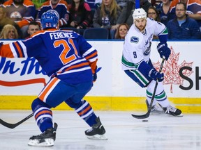 Nov 1, 2014; Edmonton, Alberta, CAN; Vancouver Canucks right wing Zack Kassian (9) controls the puck as Edmonton Oilers defenseman Andrew Ference (21) defends during the first period at Rexall Place. Mandatory Credit: Sergei Belski-USA TODAY