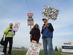 Marla Vanderaa, left, Ed Vanderaa and Mary-Lynn Cooper were among wind turbine protesters outside the Suncor refinery gates in Sarnia Monday afternoon. They were protesting the company's plans to build wind turbines in Lambton County. PAUL MORDEN/ THE OBSERVER/ QMI AGENCY