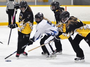 Karly Rock (8) of the Mitchell U19 ringette team turns to stab the ring while being harassed by this Goderich opponent last Thursday, Oct. 30 in WRRL action. The Stingers won, 5-3. ANDY BADER/MITCHELL ADVOCATE
