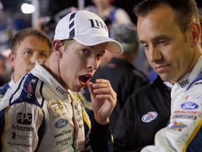 Brad Keselowski (left) rubs his lip after getting into a fight with Jeff Gordon at Texas Motor Speedway on Sunday. (Getty Images/AFP)