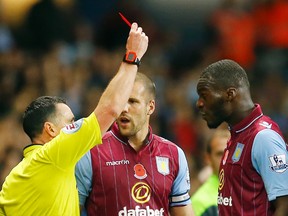 Referee Neil Swarbrick shows Aston Villa’s Christian Benteke (right) a red card during their English Premier League match against Tottenham Hotspur at Villa Park in Birmingham November 2, 2014. (REUTERS/Darren Staples)