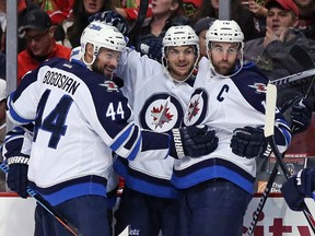 Michael Frolik celebrates his first period goal with Zach Bogosian and Andrew Ladd last Sunday night against Chicago. The Jets host the first-place Nashville Predators on Tuesday night. (Jonathan Daniel/Getty Images/AFP)