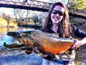 Ashley Rae holds a beautifully coloured male brown trout caught in a Lake Ontario tributary. (Supplied photo)