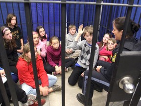 Students from Perth Road Public School listen to OPP Const. Stacey Campbell while in a mock jail cell during the Racing Against Drugs program at the Thompson Drill Hall on Tuesday. (Michael Lea/The Whig-Standard)