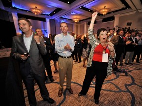Trent Muntz (L-R), Jonathan Mitchell and Irina Cooper, supporters of Republican Florida Governor Rick Scott, cheer as early results come in during a U.S. midterm elections night party in Bonita Springs, Florida, November 4, 2014. (REUTERS/Steve Nesius)