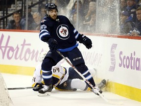 Winnipeg Jets forward Mathieu Perreault (85) challenges for the puck with Nashville Predators defenceman Victor Bartley (64) during the second period at MTS Centre.