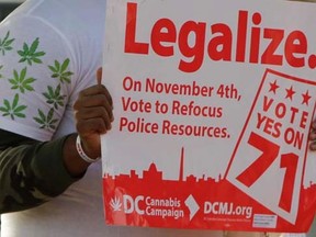 Melvin Clay of the D.C. Cannabis Campaign holds a sign urging voters to legalize marijuana, at the Eastern Market polling station in Washington November 4, 2014.        REUTERS/Gary Cameron
