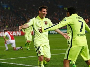 Barcelona’s Lionel Messi (left) celebrates his goal with teammate Pedro Rodriguez during their Champions League match against Ajax at Amsterdam Arena November 5, 2014. (REUTERS/Michael Kooren)
