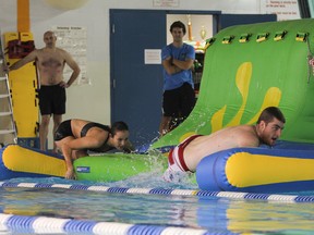 Participants climb along one of the obstacles in the 3rd annual RMC/United Way Waterborne Obstacle Course Challenge at the Kingston Military Community Sports Centre Pool on Wednesday November 5, 2014. The event is based on training third year cadets receive and all the money raised will go the the United Way. Julia McKay/Kingston Whig-Standard/QMI Agency