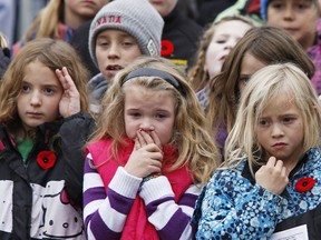 Grade 3 students during the playing of the Last Post during a 2013 Remembrance Day service at the Cenotaph in Bridgenorth, Ont. (Clifford Skarstedt/QMI AGENCY)