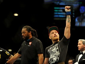 Conor McGregor (blue gloves) celebrates beating Dustin Poirier in a featherweight fight during UFC 178 at MGM Grand Garden Arena. (Stephen R. Sylvanie/USA TODAY Sports)