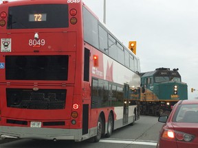 a railway crossing gate sits atop an OC Transpo doubledecker bus along Fallowfield Dr., Thursday morning. Almost the whole bus is ahead of the safe stop line on the roadway - just metres from a Via Rail train. (TOM CLARKE Submitted image)