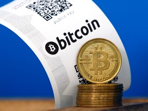 A bitcoin paper wallet with QR codes and coins are seen in an illustration picture taken at La Maison du Bitcoin in Paris, July 11, 2014. (BENOIT TESSIER/Reuters)