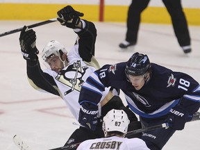 Pittsburgh Penguins defenceman Robert Bortuzzo (l) is checked by Winnipeg Jets center Bryan Little during NHL hockey in Winnipeg, Man. Thursday, November 06, 2014.Brian Donogh/Winnipeg Sun/QMI Agency