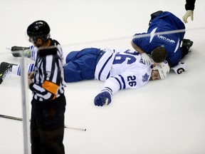 Toronto Maple Leafs right wing Daniel Winnik (26) is treated on the ice after sustaining an injury in the first period against the Colorado Avalanche at Pepsi Center.  Ron Chenoy-USA TODAY Sports