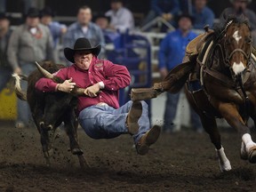 Tanner Milan (Cochrane, AB) during the second go round of the steer wrestling competition at the Canadian Finals Rodeo at Rexall Place, in Edmonton Alta., on Thursday Nov. 6, 2014. David Bloom/Edmonton Sun/QMI Agency