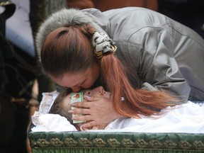 An acquaintance kisses the forehead of Andrei Eliseev during a funeral ceremony in the village of Hrabary (Grabari) in Donetsk, eastern Ukraine, November 7, 2014. Eliseev was one of two teenagers were killed by shelling while out playing on a school sports field in the rebel-controlled city of Donetsk in eastern Ukraine on November 5, the city's administration said. REUTERS/Maxim Zmeyev