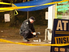 A Toronto Police officer works at the scene of the city's 49th murder of 2014. (MANNY RODRIGUES/Toronto Sun)