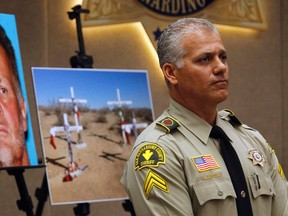 San Bernardino Sheriff deputy Randy Naquin stands in front of a mug shot of Charles "Chase" Merritt during a news conference about the McStay murder case in San Bernardino, California November 7, 2014. The lone suspect, Merritt has been arrested and charged with four counts of murder in the slaying of a couple and their two young sons, whose skeletal remains were found buried last year in the California desert, police and prosecutors said on Friday. REUTERS/Alex Gallardo