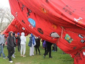 Students from Frontenac Secondary School and Module L'Acadie look over the newly wrapped Time sculpture prior to a ceremony Friday on the site. The fabric contains messages and images honouring Canada's fallen servicemen from World War One. FRI., NOV 7. 2014 KINGSTON, ONT. MICHAEL LEA THE WHIG STANDARD QMI AGENCY