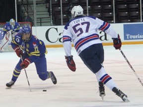 Sweden's Tim Wahlgren lugs the puck up the ice with USA defenceman Riley Tufte lining him up during Friday's World Under-17 Hockey Challenge semifinal in Sarnia. The Americans won 4-1 to punch its ticket to Saturday's gold-medal game. (TERRY BRIDGE, The Observer)