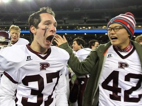 St. Paul's Crusaders RB Christian Johnson (left) and DL Chanhee Park celebrate defeating the Steinbach Sabres in the Winnipeg High School Football League's AA final at Investors Group Field in Winnipeg, Man., on Fri., Nov. 7, 2014. Kevin King/Winnipeg Sun/QMI Agency