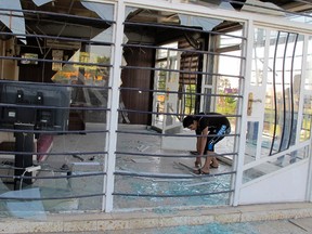 A man cleans his shop at the site of a car bomb attack in Baghdad's Al-Amil district November 8, 2014. Car bombs killed 12 people in the Iraqi capital and the city of Ramadi to the west on Saturday, police and medical sources said. Two car bombs exploded in separate attacks in Baghdad's mainly Shi'ite Amil district, said a police source.  REUTERS/Ahmed Malik