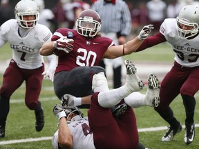 Marauders RB Chris Pezzetta (20) is tackled by Gee-Gees DL Ettore Lattanzio (49) during the third quarter. McMaster Marauders def.. Ottawa Gee-Gees  42-31 during OUA semi-final action in Hamilton, Ont. at  Ron Joyce Stadium  on Saturday November 8, 2014. Jack Boland/Toronto Sun/QMI Agency