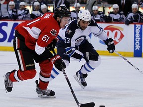 Ottawa Senators' Mark Stone (61) skates away from Winnipeg Jets' Dustin Byfuglien (33) in the third period during NHL action in Ottawa, Ont. on Thursday January 2, 2014. The Senators won 4-3. Darren Brown/Ottawa Sun/QMI Agency