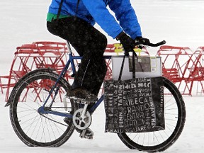 A man bikes in the snow at Churchill Square on Saturday. (Perry Mah/Edmonton Sun)