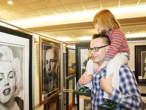 Three-year-old Imogen Sibley and her dad, Jason Sibley, of Exeter, Ont., check out some of the art on display at the eighth annual Oxford Creates fine art show and sale at the Oxford Golf and Country Club on Saturday, Nov. 8, 2014. JOHN TAPLEY/INGERSOLL TIMES/QMI AGENCY