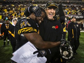Tiger-Cats head coach Kent Austin is hugged by defensive tackle Ted Laurent after they beat the Montreal Alouettes on Saturday to become the Eastern Division champions. (Mark Blinch/Reuters)