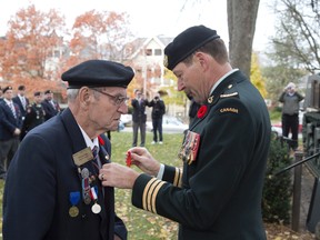 Lieutenant Colonel Rick Phillips, right, presents Bill Bury with the French Legion of Honour medal at Victoria Park Sunday. Surviving veterans who fought in or for France are eligible for consideration for the honour, which is similar to a knighthood. (DEREK RUTTAN, The London Free Press)