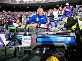 A Ravens cheerleader is taken off the field after falling while performing during a game between the Baltimore Ravens and Tennessee Titans at M&T Bank Stadium on November 9, 2014 in Baltimore, Maryland.  (Rob Carr/Getty Images/AFP)