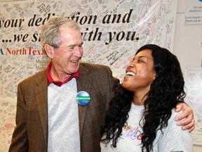 Former U.S. President George W. Bush hugs nurse and Ebola survivor Amber Vinson (R) at Texas Health Presbyterian Hospital in Dallas, Texas November 7, 2014. (REUTERS/Texas Health Presbyterian Hospital Dallas/Handout via Reuters)