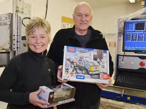 Lisa Hanlon, CNC technician in charge of carving the original ice truck, displays the new resin model being offered by Canadian tire, while Iceculture cofounder Julian Bayley shows off the MegaBloks version of the now famous truck.