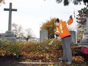 Belleville public works employee Kelsey Foote rakes leaves around the cenotaph at Memorial Park Monday, Nov. 10, 2014 prior to this year's Remembrance Day service.- JEROME LESSARD/THE INTELLIGENCER