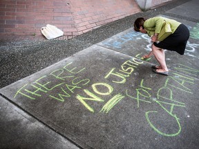 An animal rights activist writes a message in front of B.C. Provincial Court after the sentencing of Brian Whitlock in Vancouver, June 12, 2013. (CARMINE MARINELLI/QMI Agency)