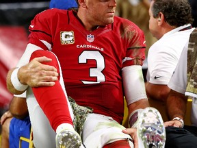 Cardinals QB Carson Palmer reacts as he is taken off the field on a cart after suffering a knee injury duing second half action against the Rams in Phoenix on Sunday. (Mark J. Rebilas/USA TODAY Sports)